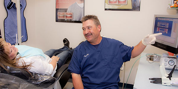 Dr. Beckwell DDS consulting his patient  about a dental procedure.